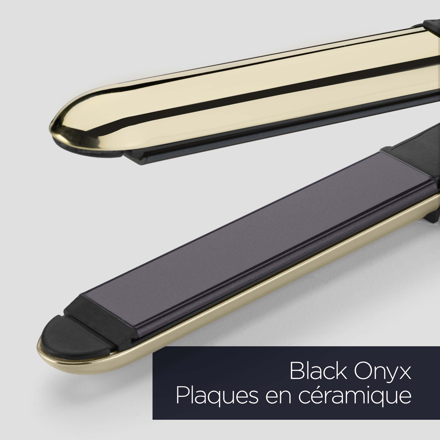 Gros plan sur un lisseur avec des plaques en céramique dorées et noires.