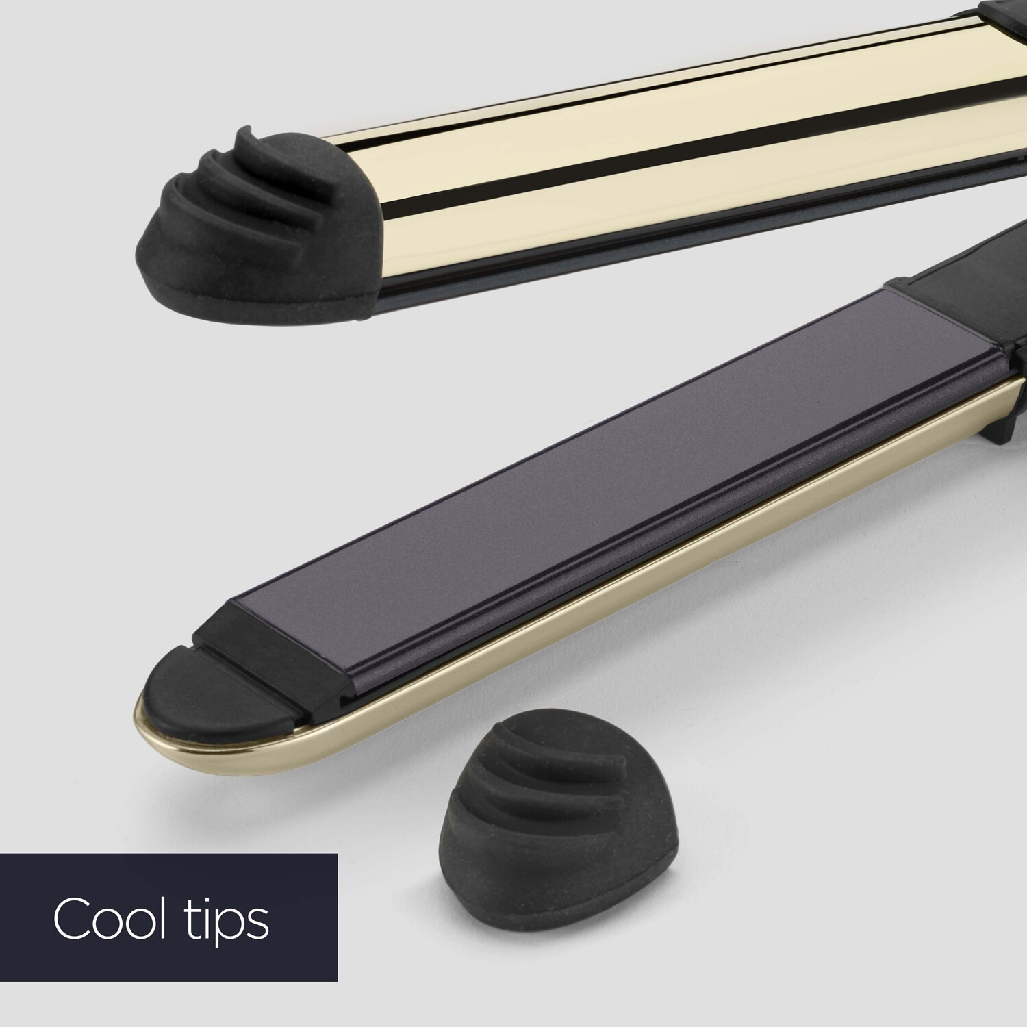 Hair straighteners, black and gold, with a detached cool tip, on a white background.