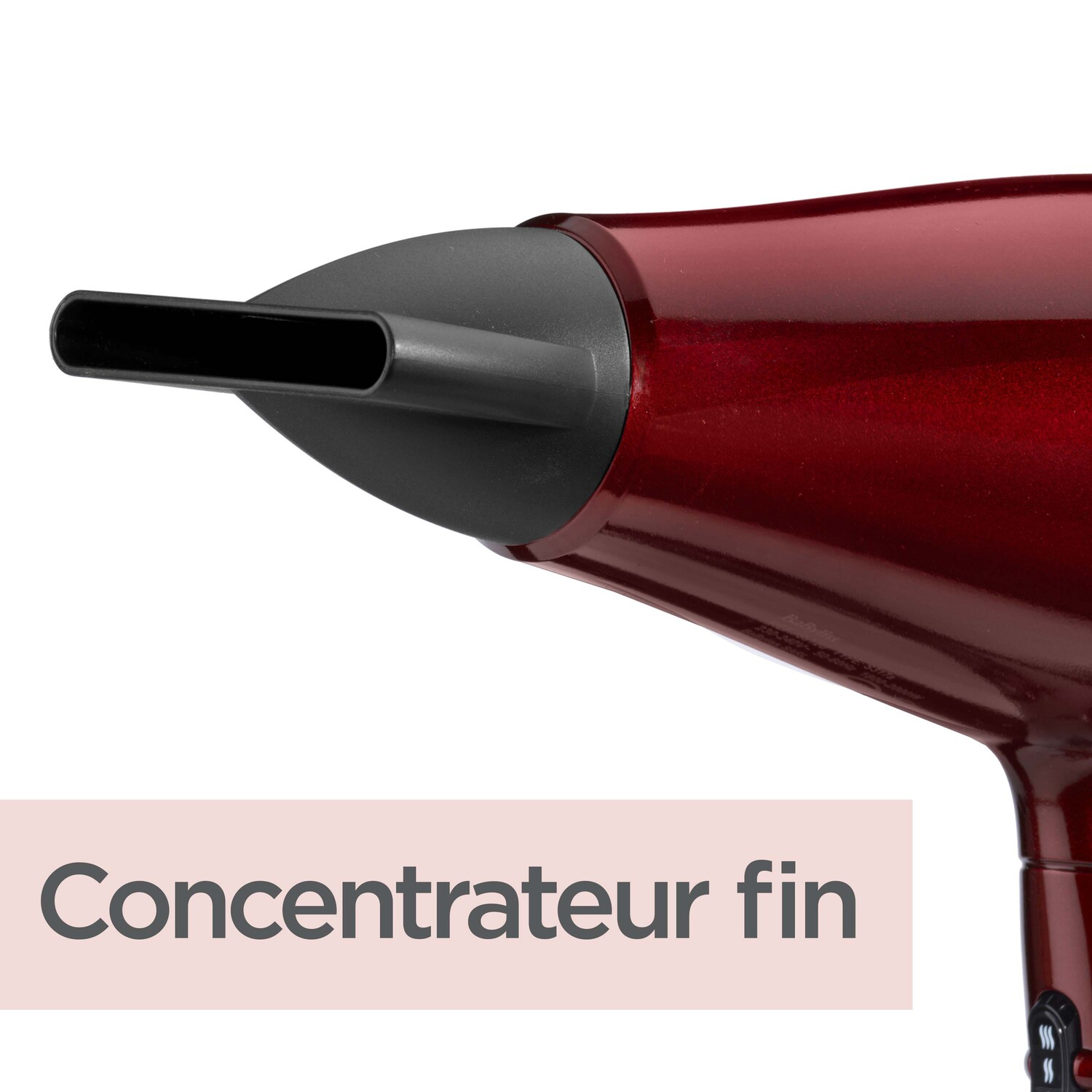 Gros plan de la buse d'un sèche-cheveux rouge avec concentrateur noir.