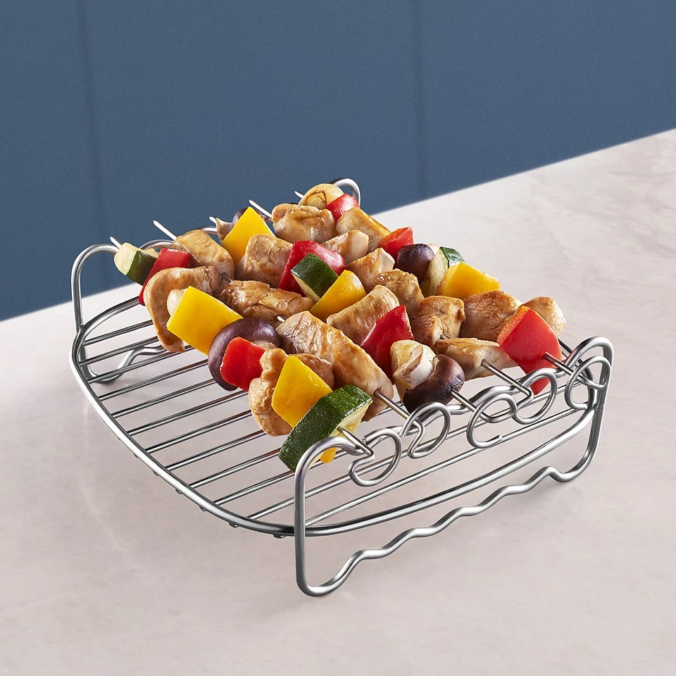 Grillowane szaszłyki na metalowym stojaku. Biały blat.