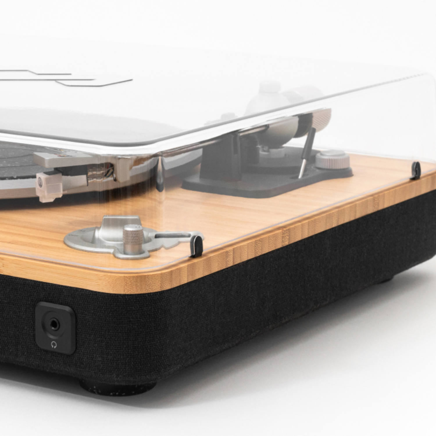 Gros plan d'une platine vinyle en bois avec couvercle transparent.