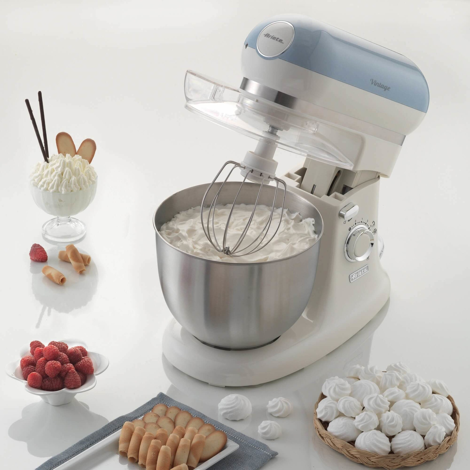Un mixer Ariete bianco e blu con panna montata e meringhe.