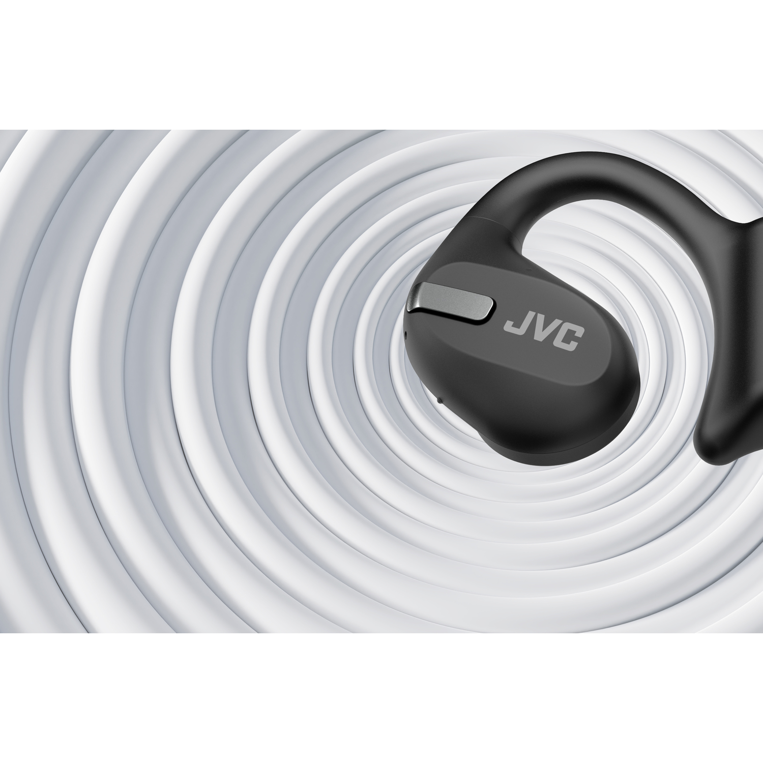 Un écouteur JVC noir sur un fond blanc tourbillonnant. L'écouteur porte le logo JVC.
