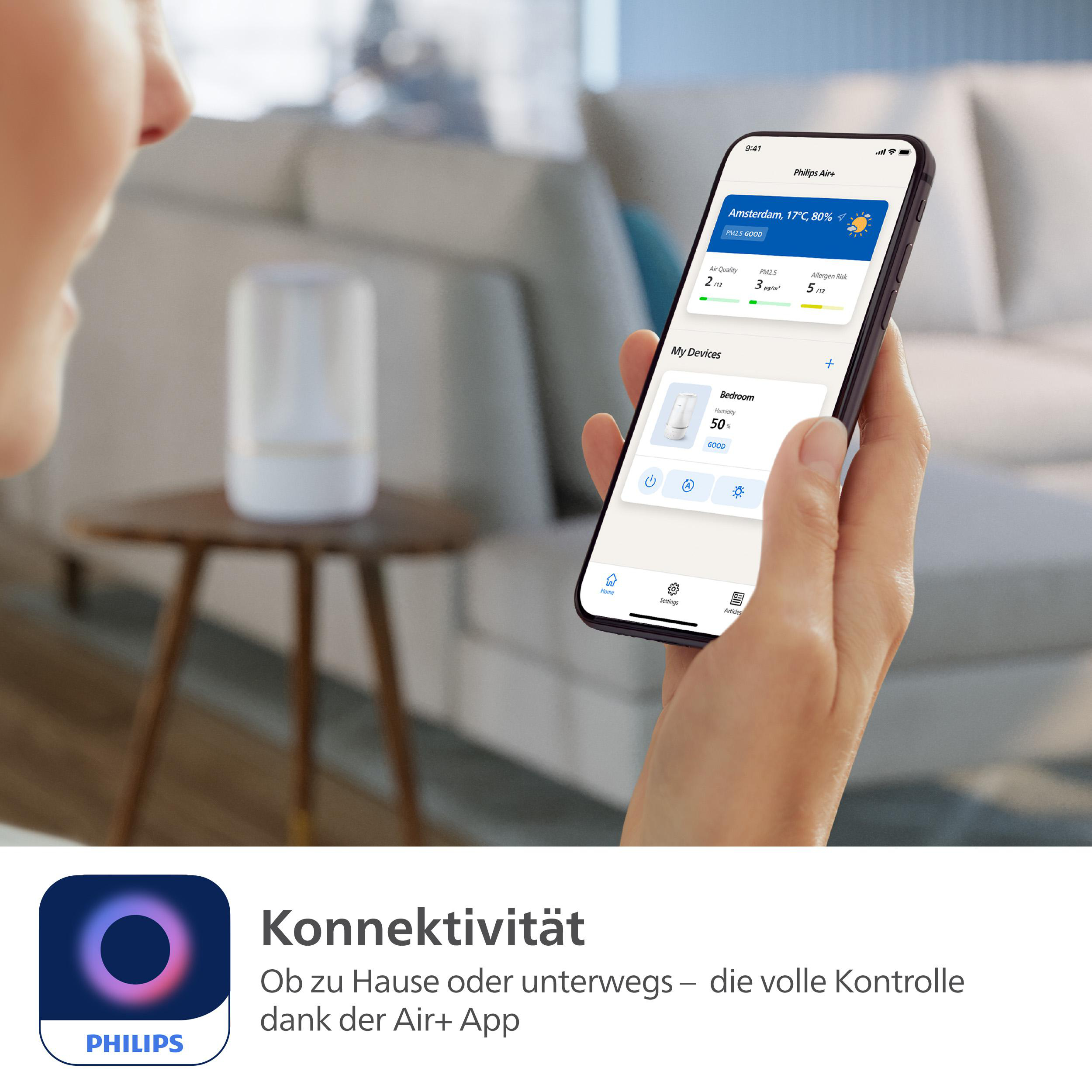 Person hält Smartphone mit App, mit weißem Luftreiniger.