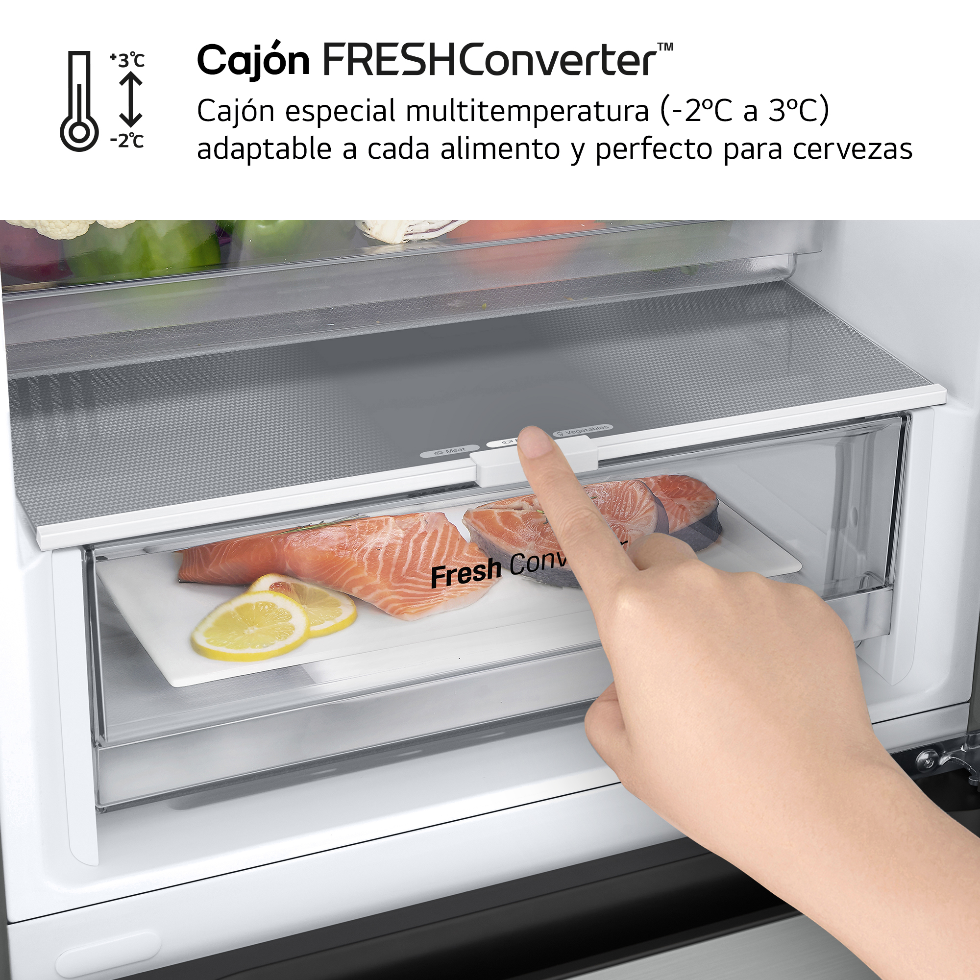 La mano de una persona señalando un cajón del refrigerador con salmón y limones dentro.