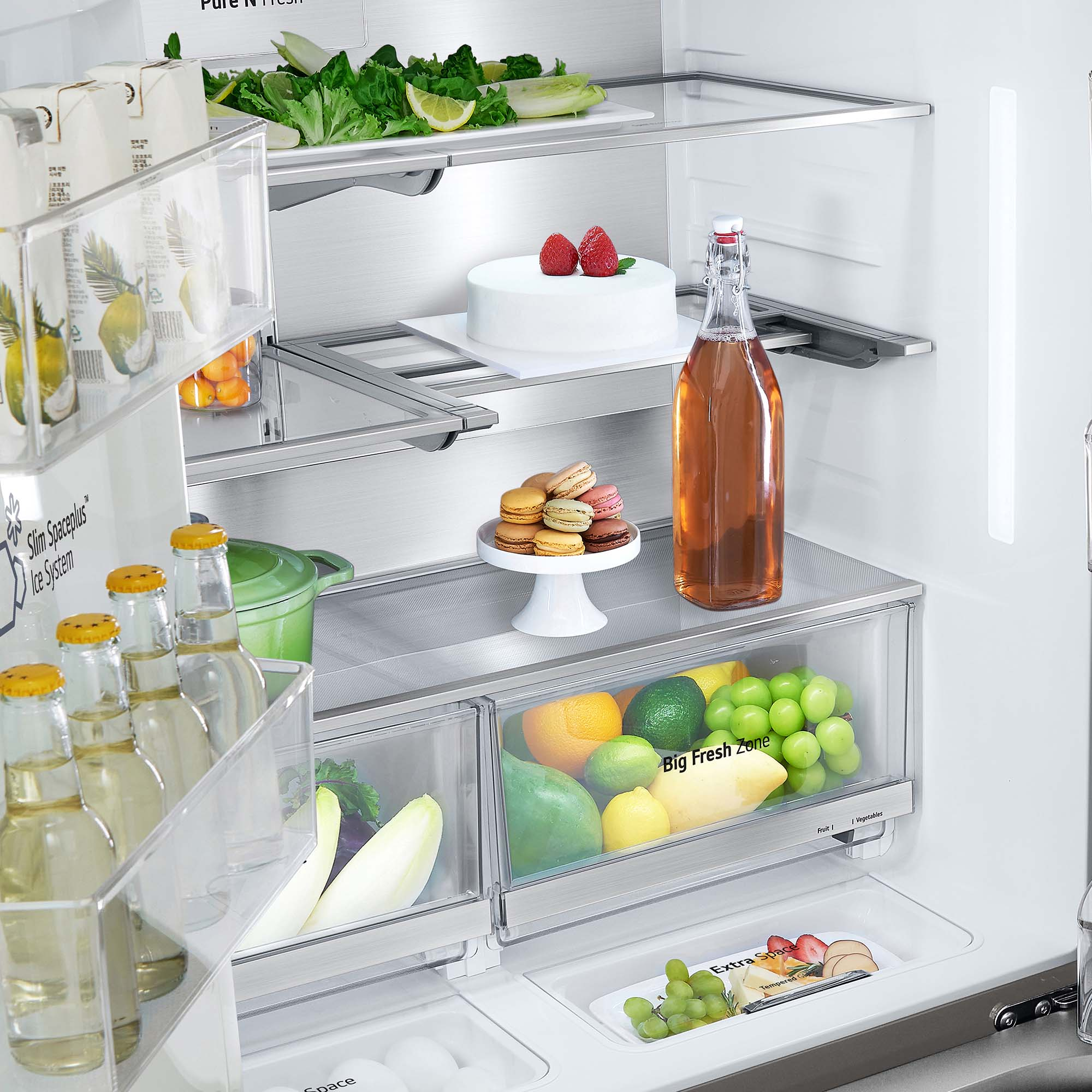 Interior de refrigerador con comida: pastel, macarons, fruta y bebidas.