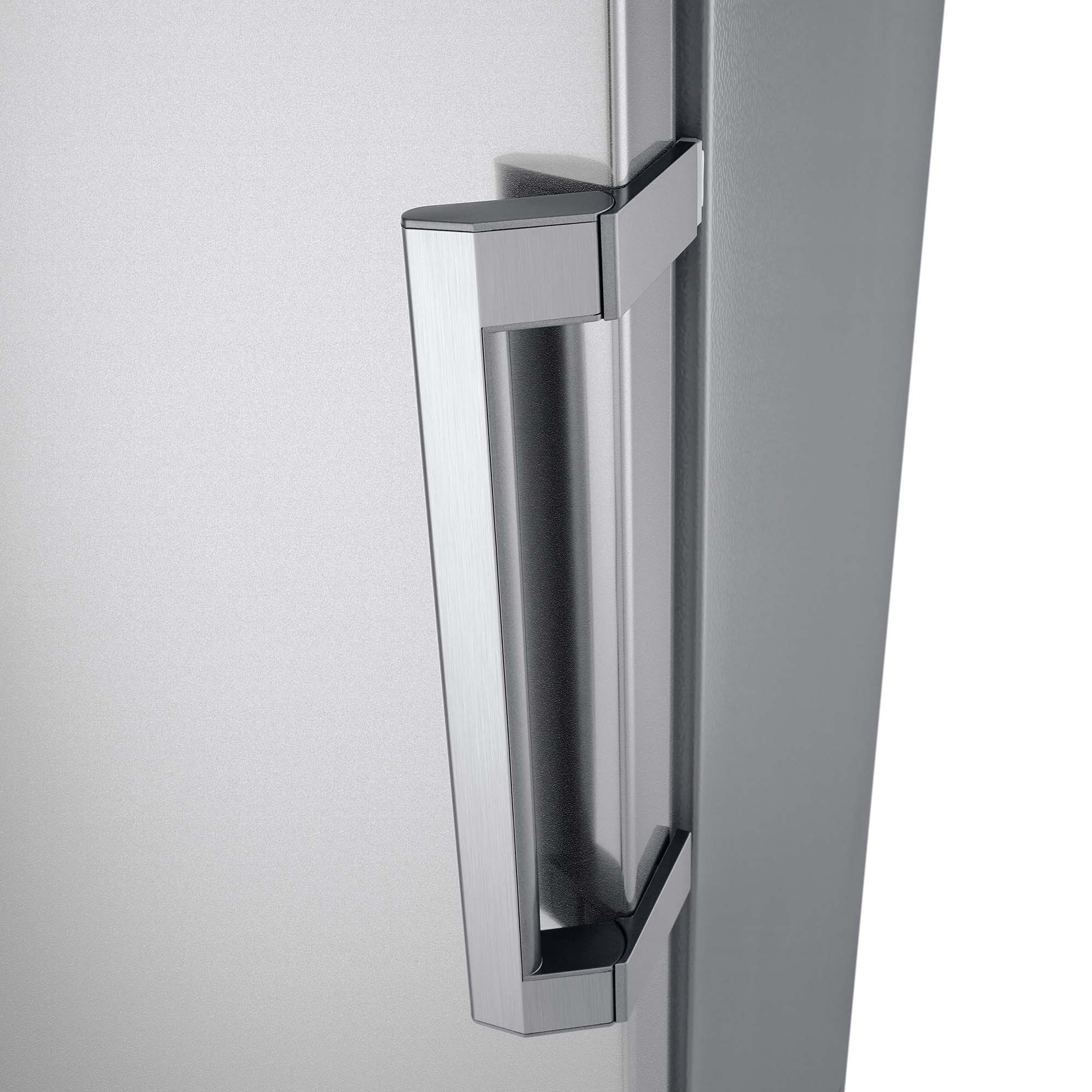Primer plano de un tirador de frigorífico de acero inoxidable sobre un fondo gris.