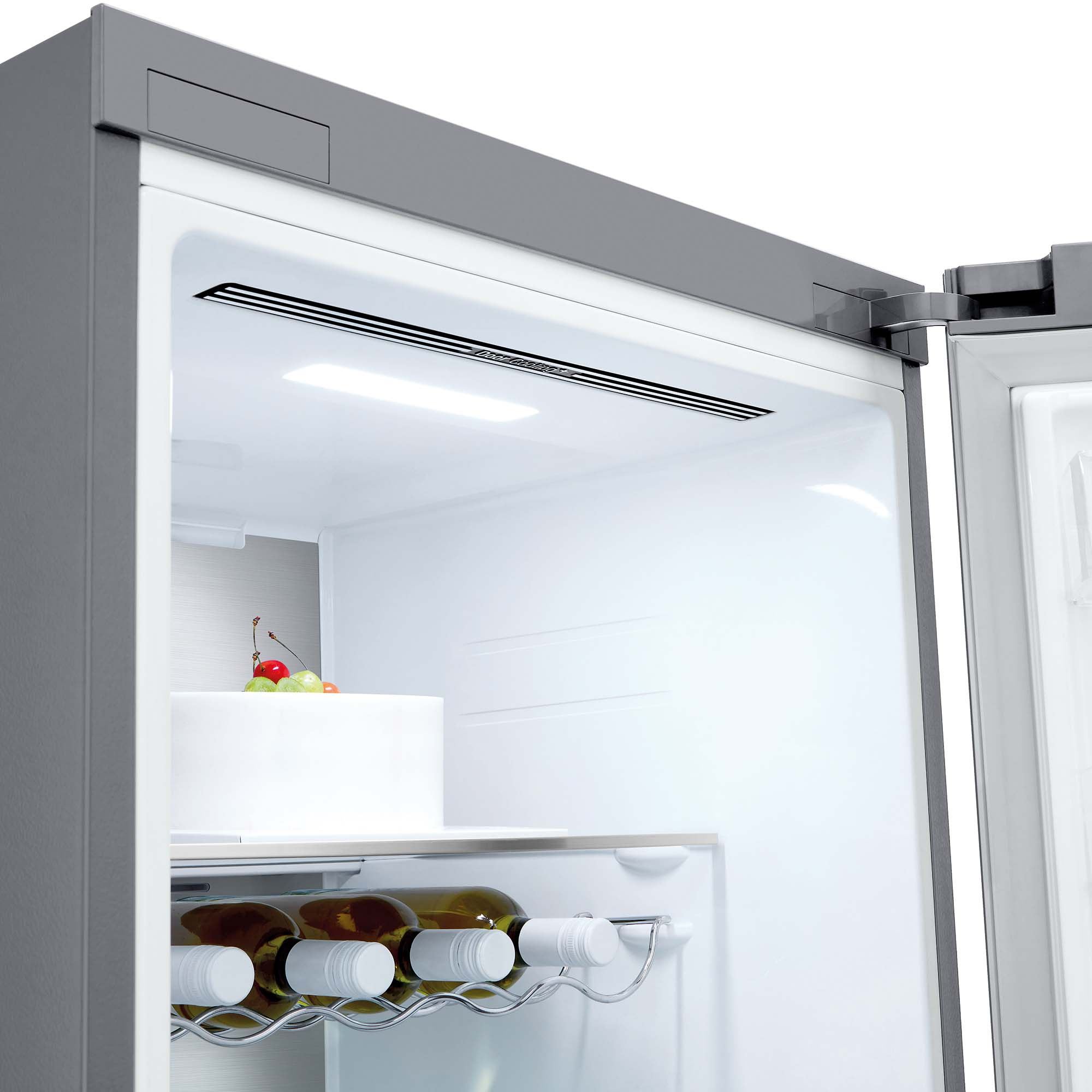 Interior del refrigerador. Un pastel con fruta y botellas de vino son visibles. El interior es blanco y brillante.