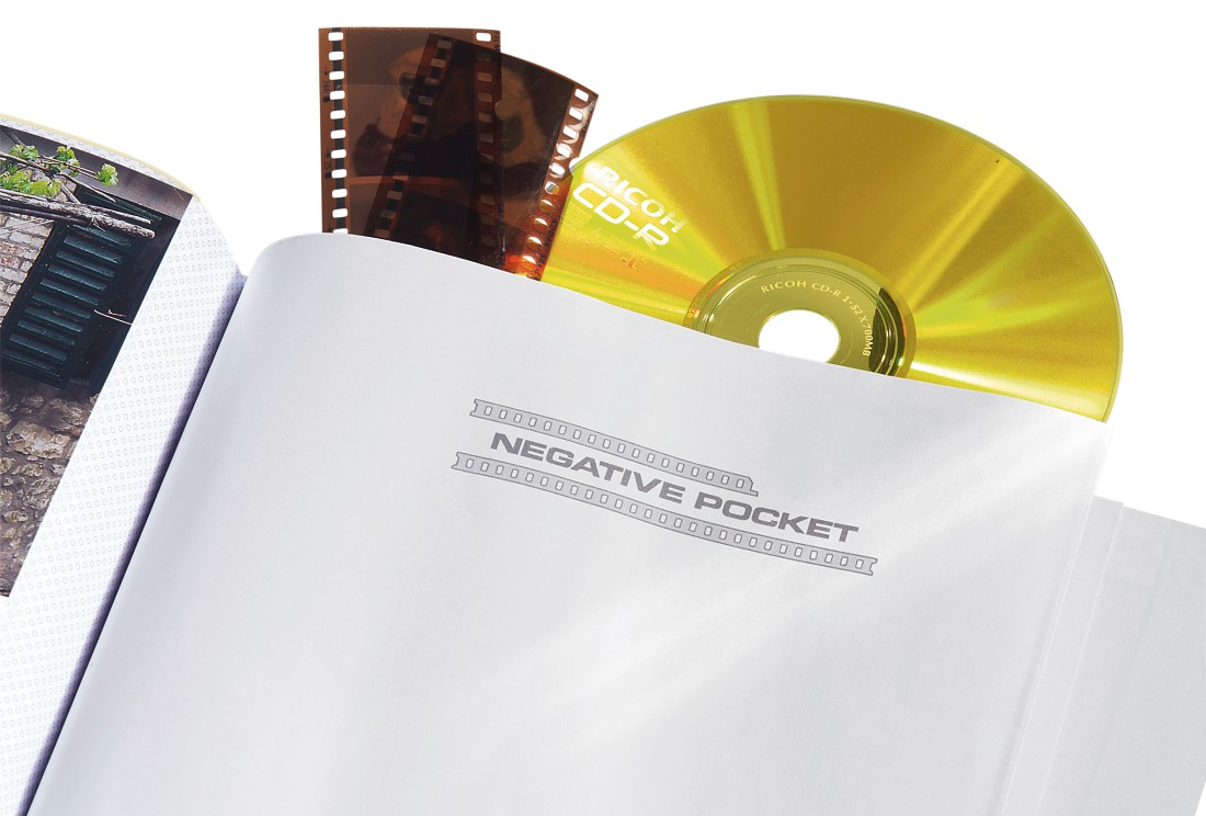 Egy filmszalag és egy CD egy negatív zsebben van. A zseb egy fotóalbumban van. A háttér fehér.