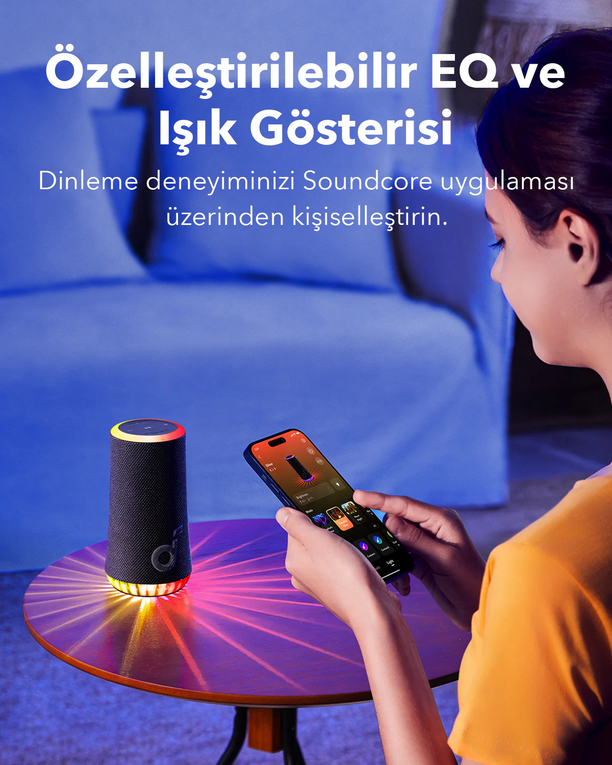 Ahşap bir masa üzerinde bir hoparlörü kontrol etmek için telefon kullanan bir kadın.