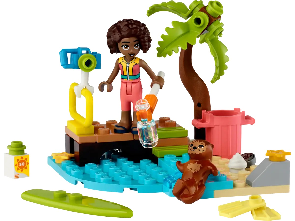 Scena Lego: dziewczyna z butelką przy aparacie, palma, wydra morska i niebieska woda.