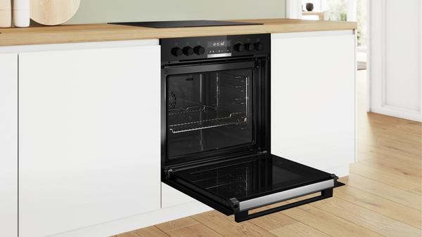 Ein offener Backofen in einem weißen Küchenschrank.
