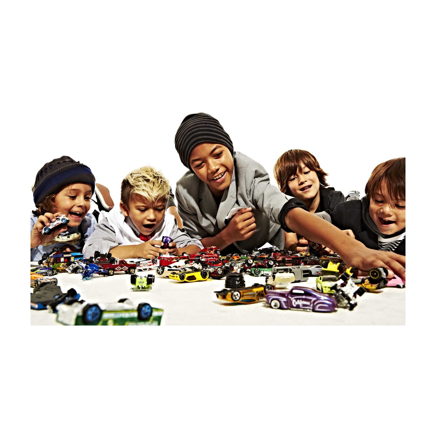 Gruppo di bambini che guardano macchinine su una superficie bianca.