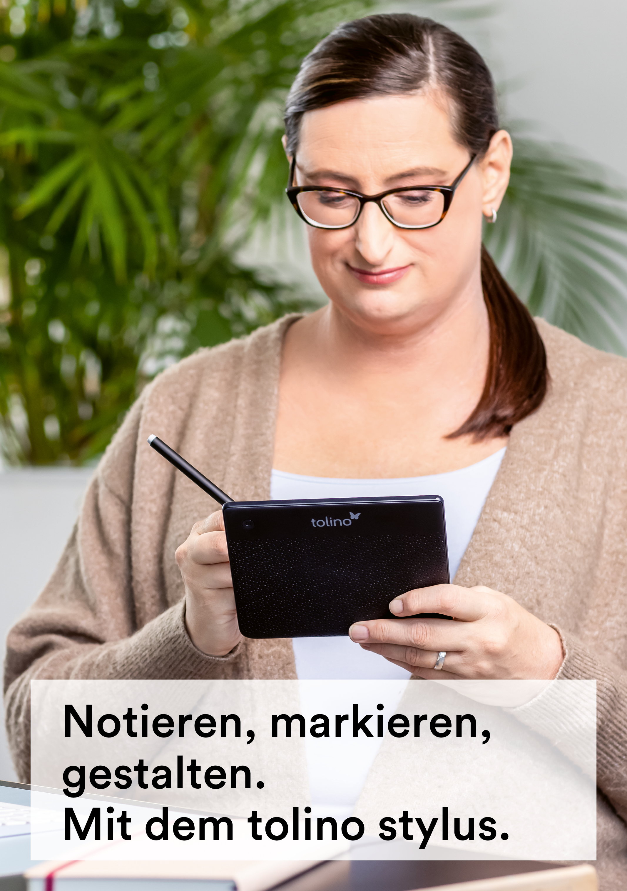Frau mit Brille, die ein Tablet mit einem Stift hält.