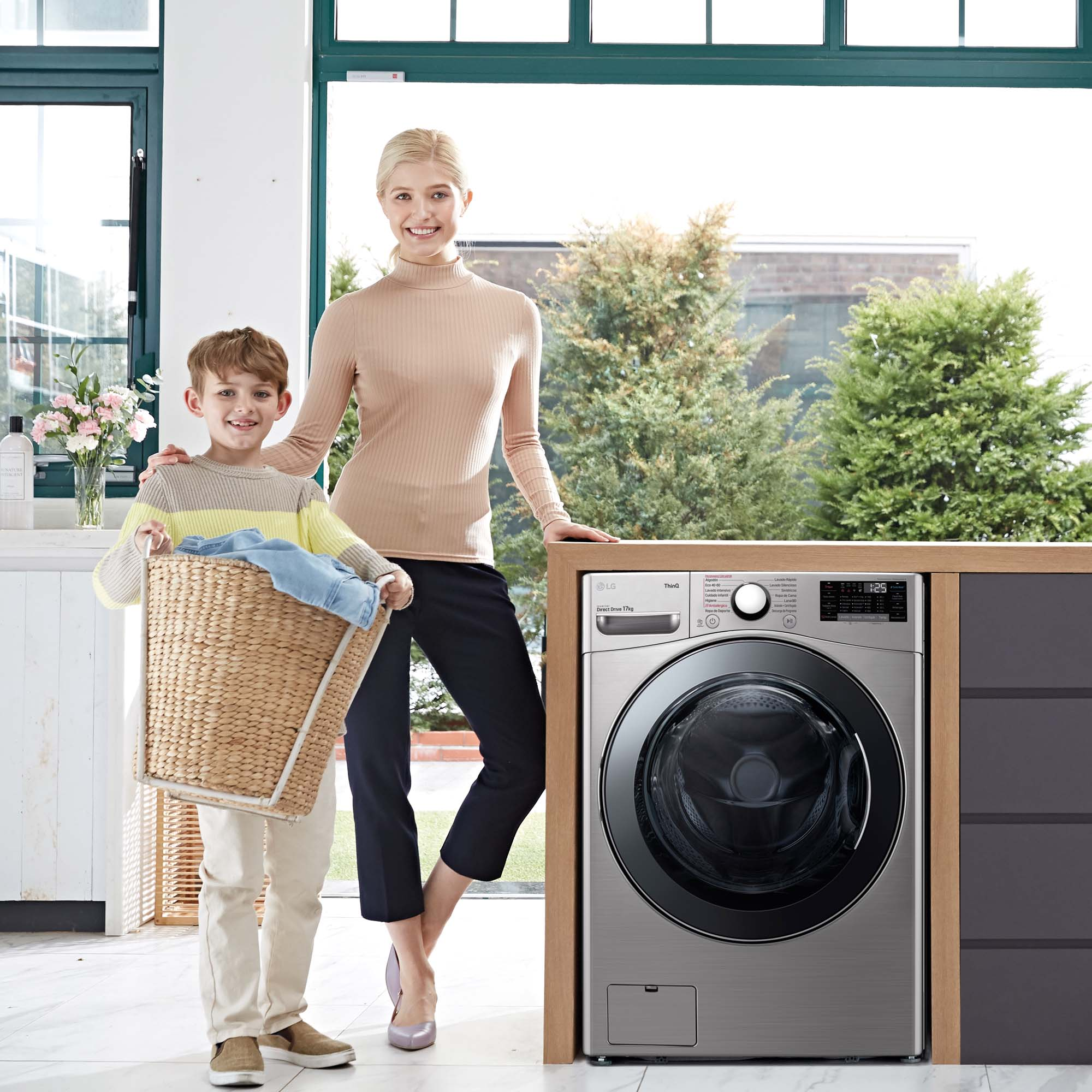 Mujer y niño con ropa sucia junto a una lavadora.