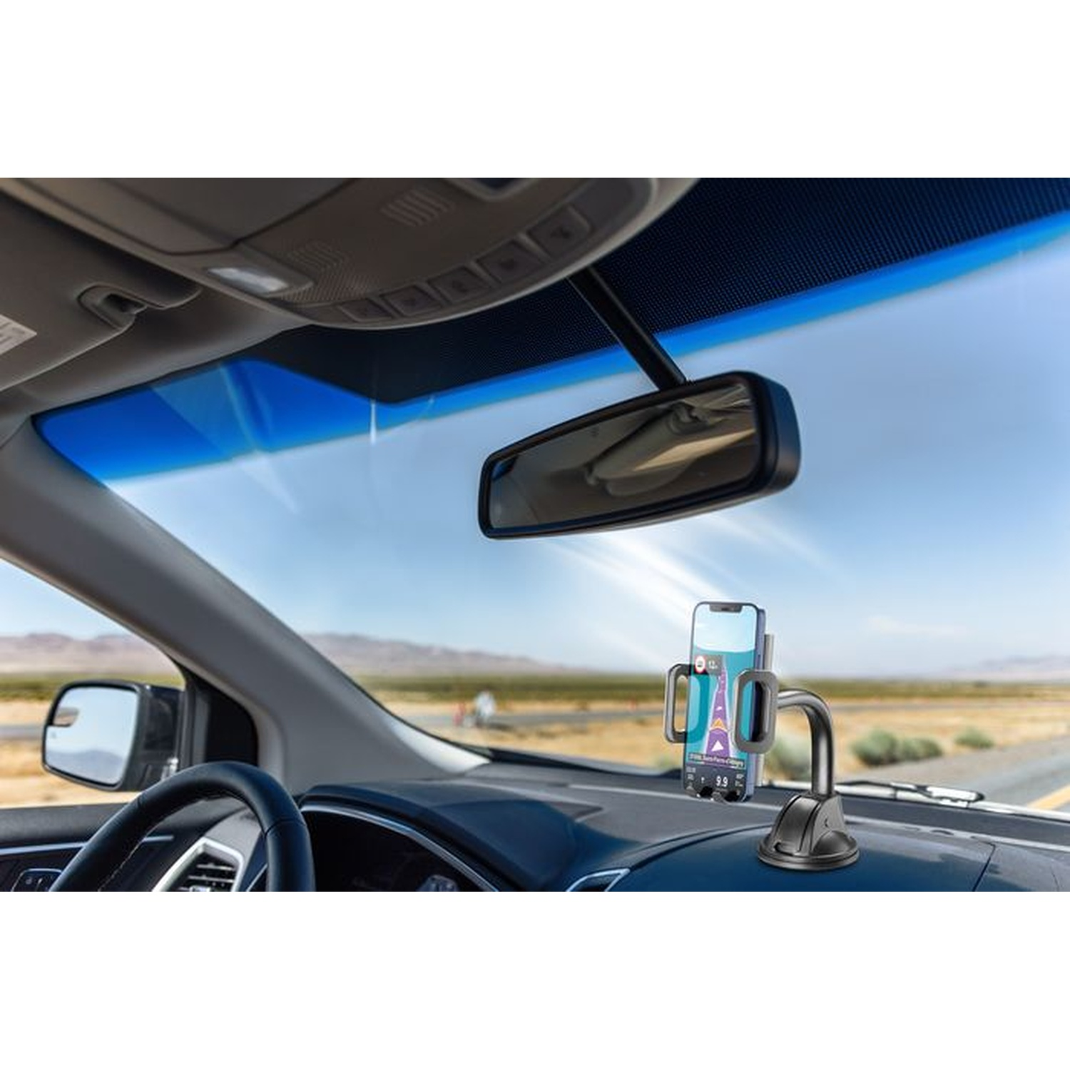 Un telefono in un supporto per auto sul cruscotto con specchietto retrovisore.