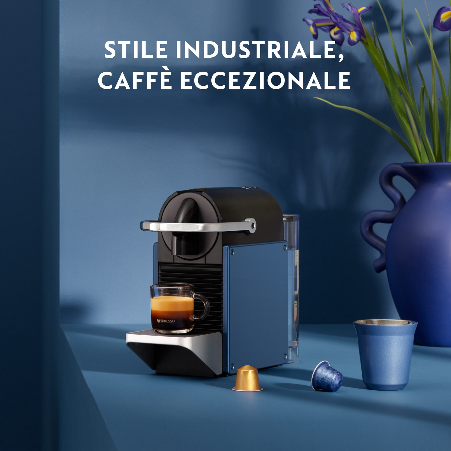 Macchina per espresso rossa con un contenitore per l'acqua in vetro e una tazza di caffè.