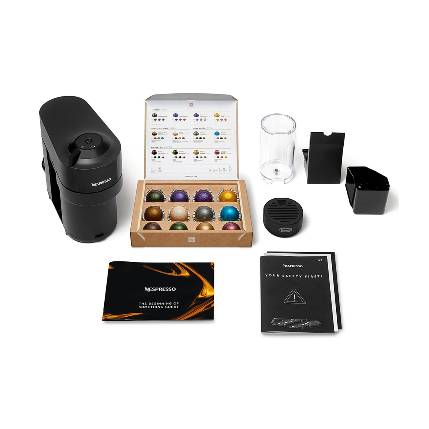 Macchina da caffè con accessori: cialde, scatola, bicchiere e strumenti per la pulizia.