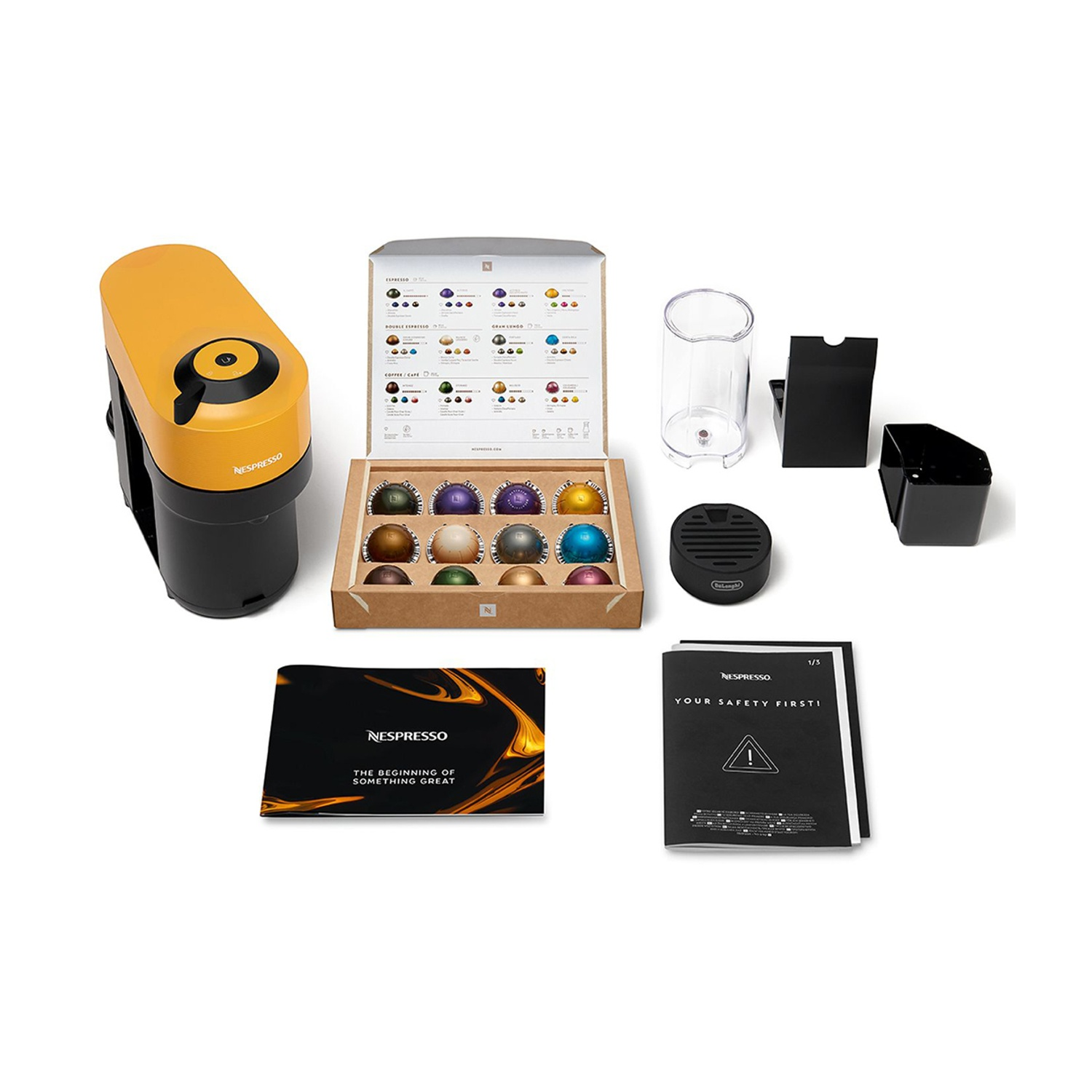 Set macchina da caffè. Macchina gialla, capsule, accessori, scatola di capsule, un manuale e una tazza.