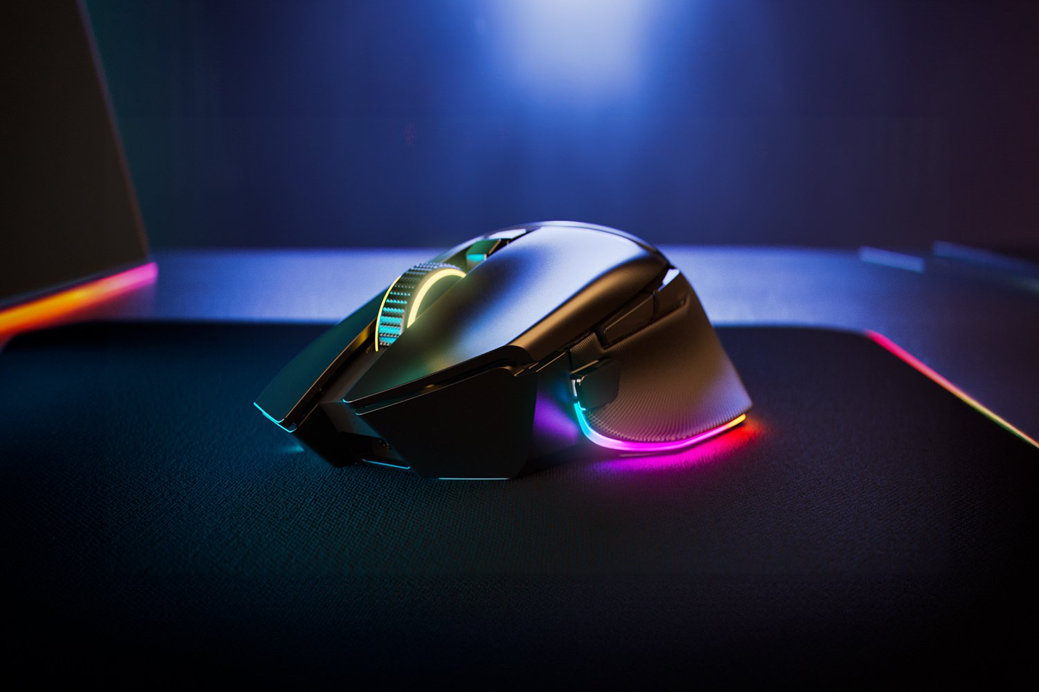 Un mouse da gioco nero su un tappetino colorato, illuminato da LED.