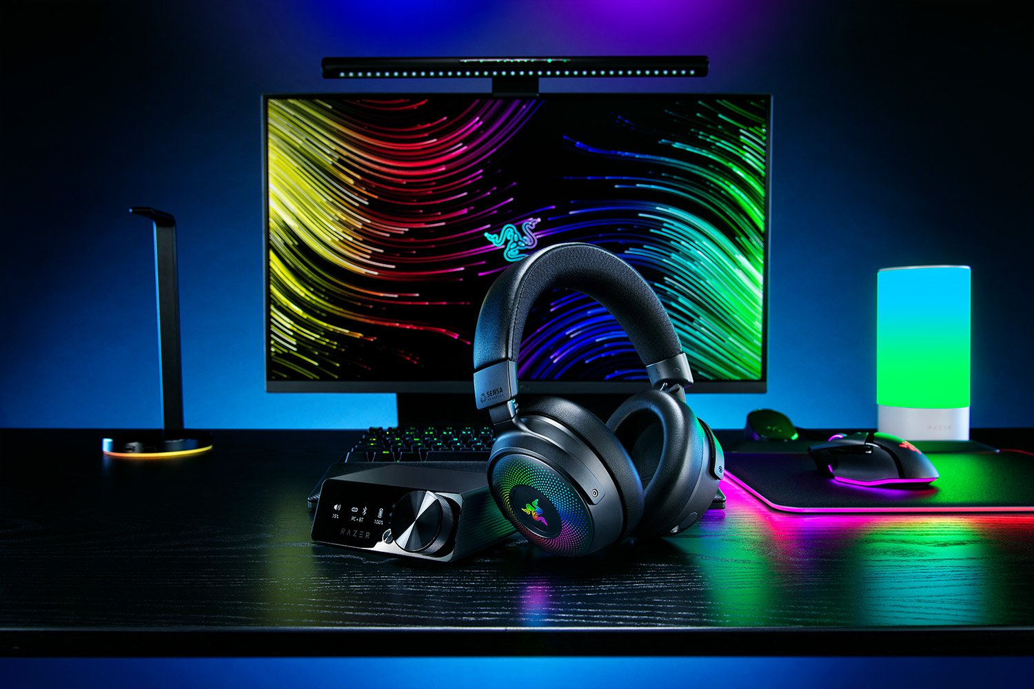Gaming-Setup: Kopfhörer, Monitor mit farbenfrohen Grafiken, Maus, Tastatur und Soundmixer.