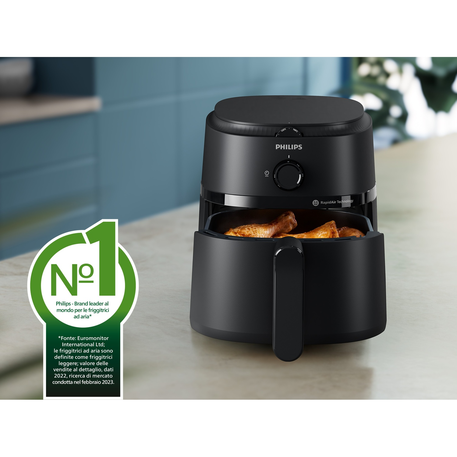 Friggitrice ad aria Philips nera con cibo cotto all'interno, sul piano cucina.