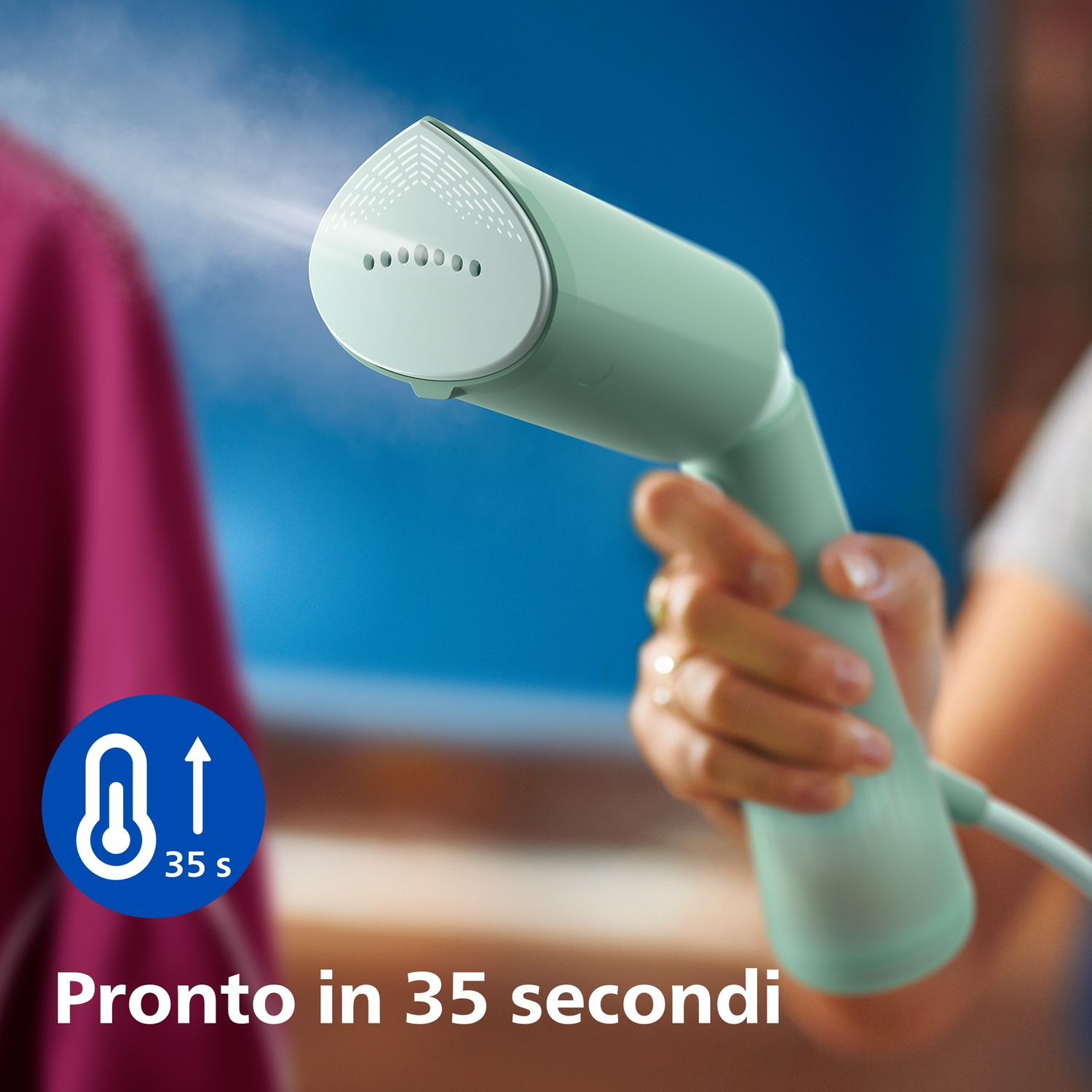Vaporizzatore portatile, colore verde menta, che vaporizza un tessuto, sfondo blu.