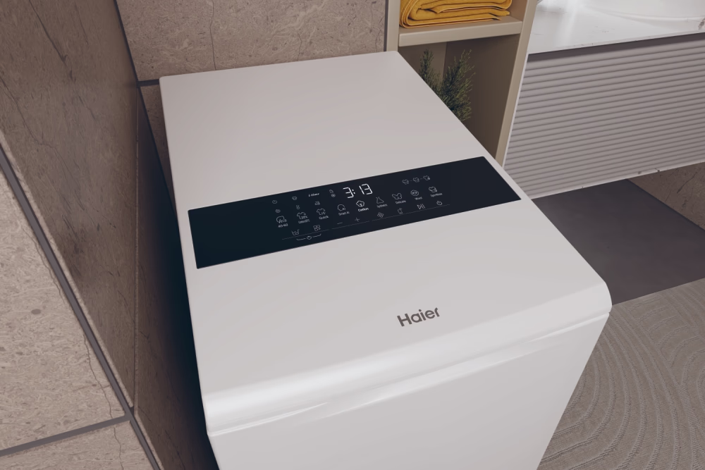 Fehér mosógép digitális kijelzővel. Látható a Haier márka.