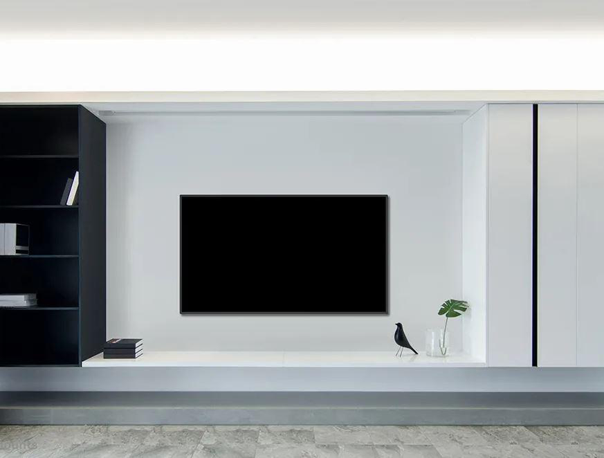 Ein an der Wand montierter Fernseher an einer weißen Wand. Darunter ein Regal mit Deko. Modernes Raumsetting.