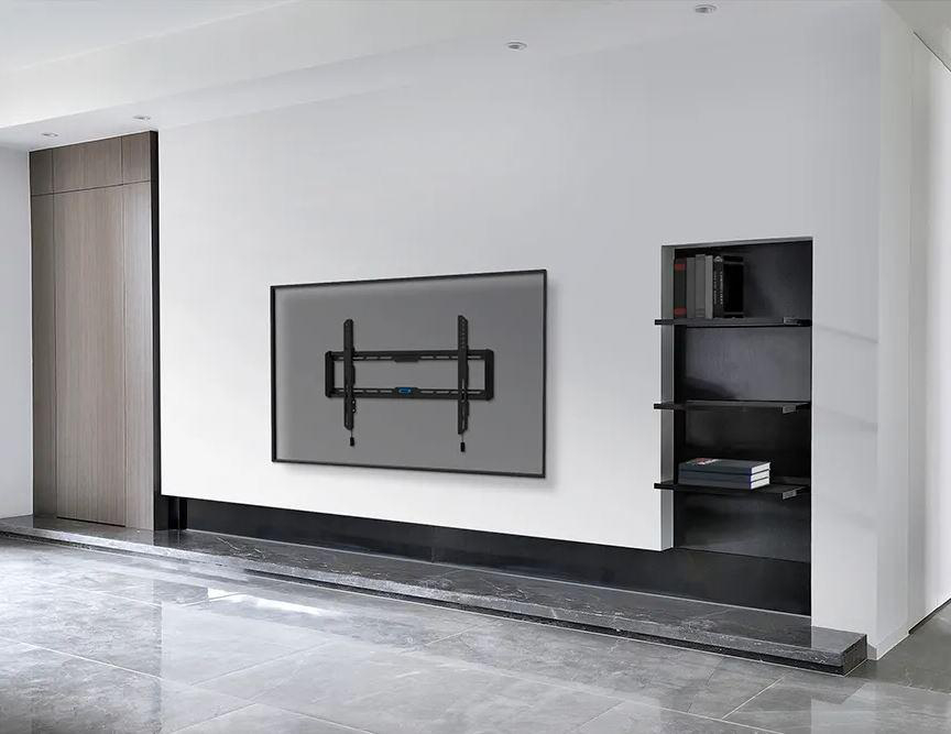 Ein Fernseher an einer weißen Wand mit schwarzem Halter und Regalen mit Büchern.