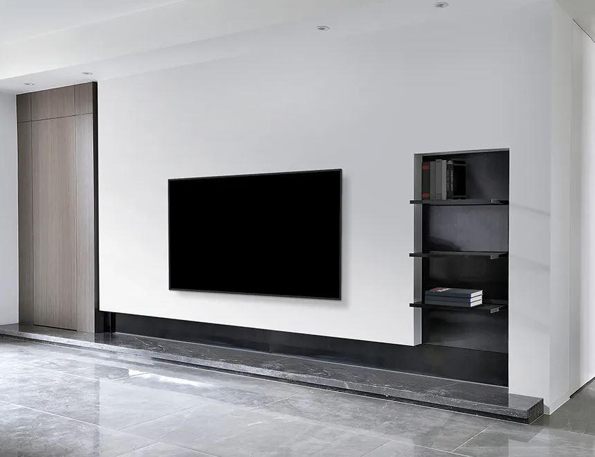 Modernes Wohnzimmer mit schwarzem Fernseher an weißer Wand und Regal.
