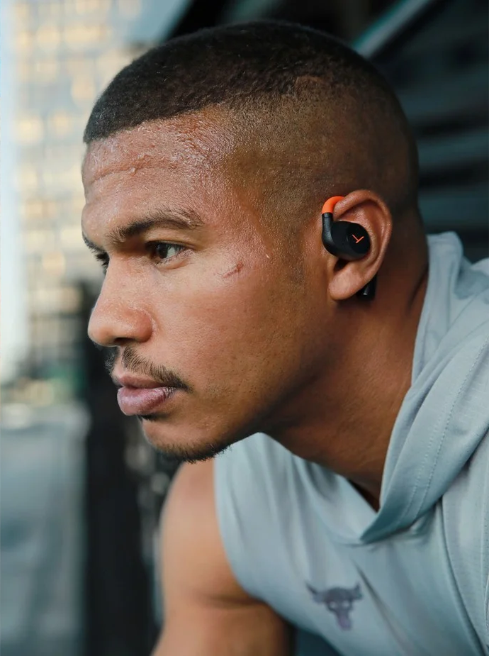 Ein Mann mit In-Ear-Kopfhörern, konzentriert sich auf sein Training.
