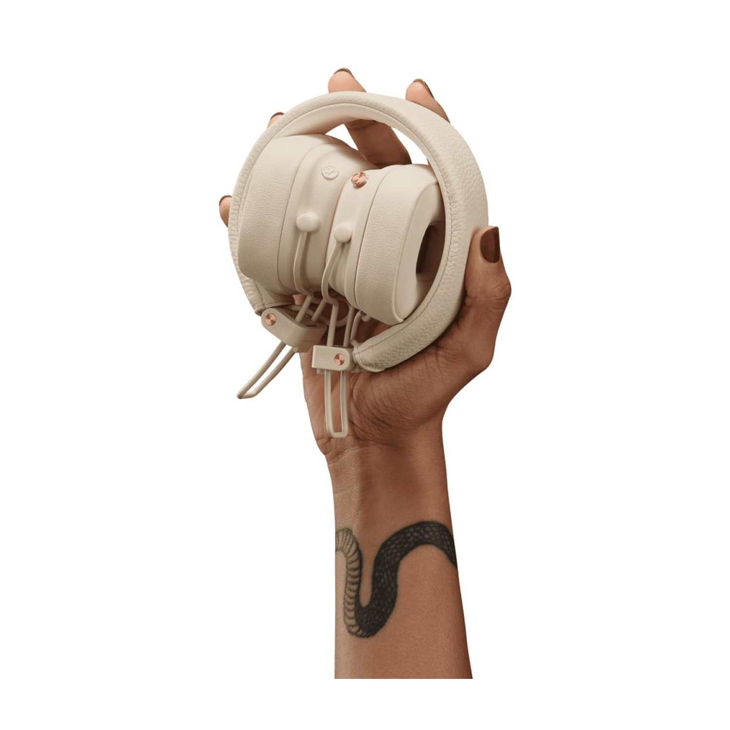Una mano che tiene delle cuffie bianche piegate con un tatuaggio visibile sul braccio.