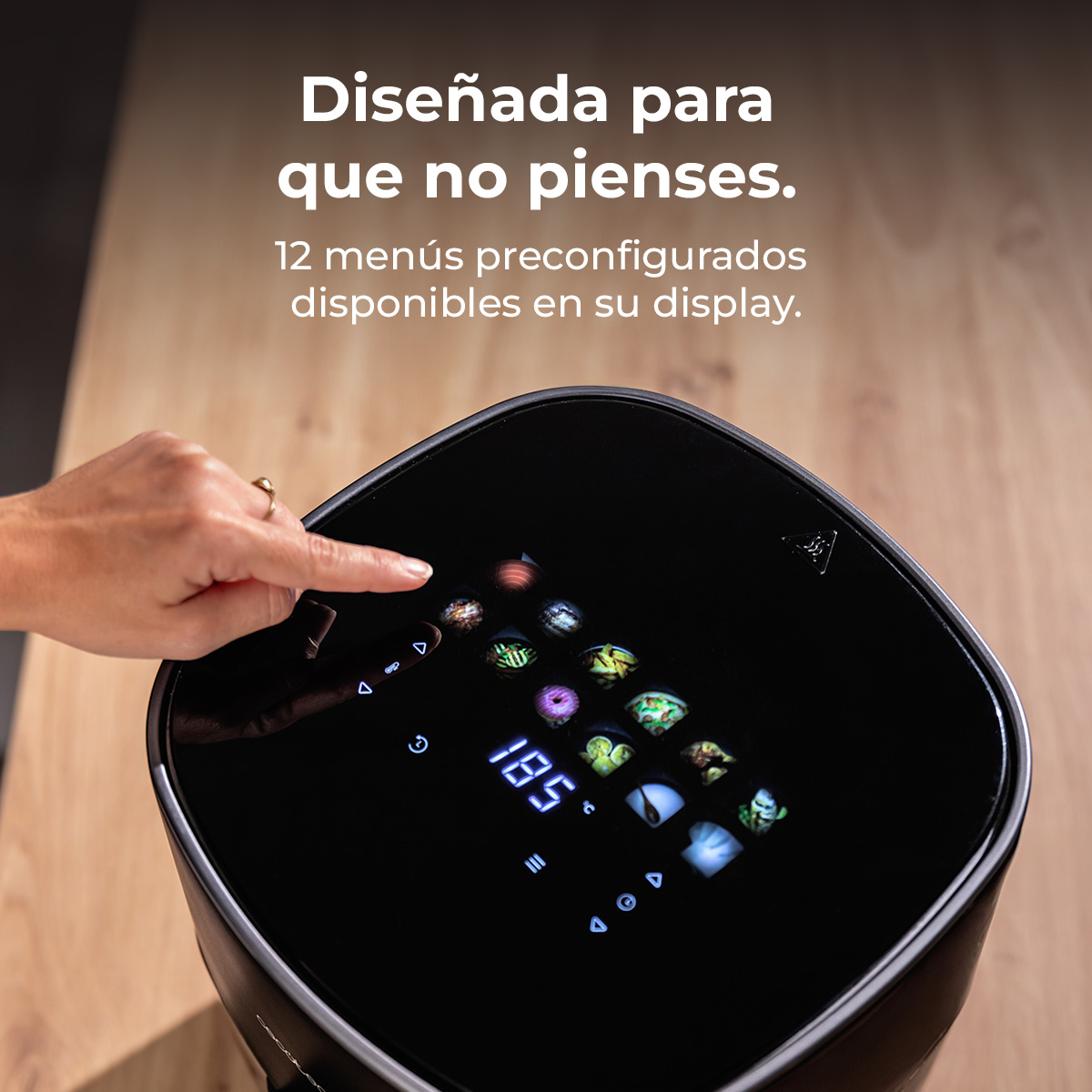 Freidora de aire negra con pantalla táctil y un dedo señalándola.