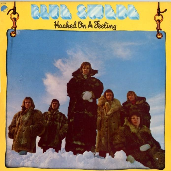 Album borítója egy bandáról, akik bundában állnak a havas háttér előtt. Cím: Hooked On A Feeling.