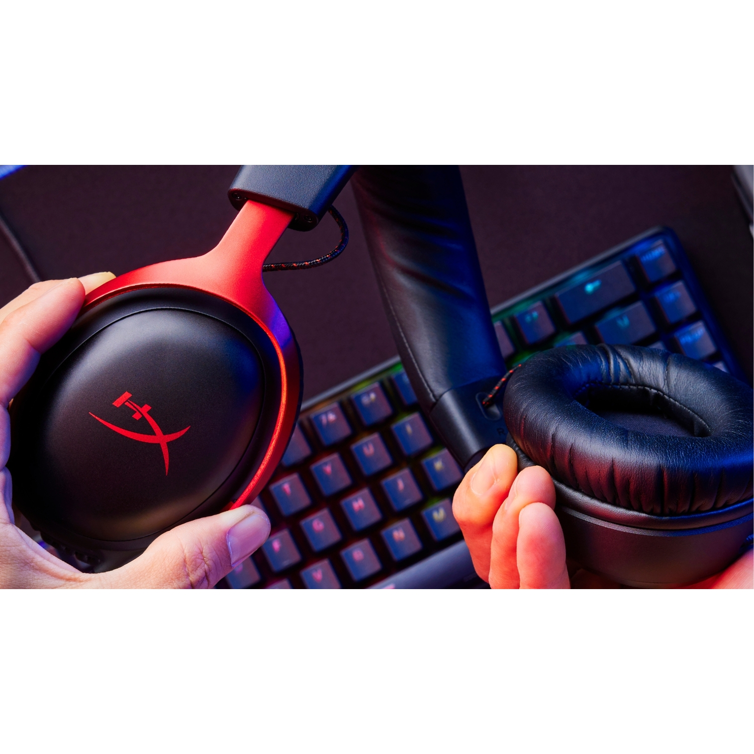 Close-up van zwarte en rode koptelefoon in de buurt van een toetsenbord.