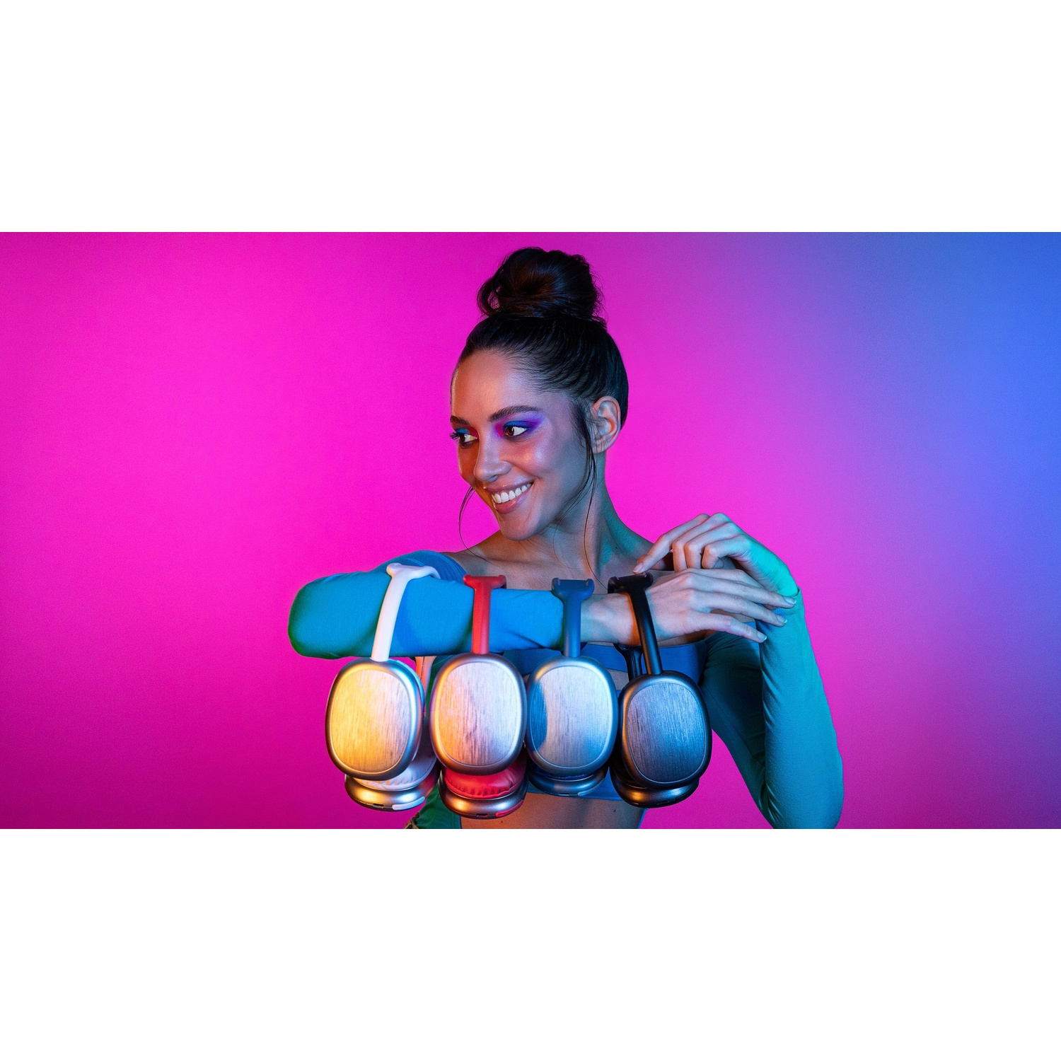 Donna con più cuffie su sfondo sfumato rosa e blu, sorridente.