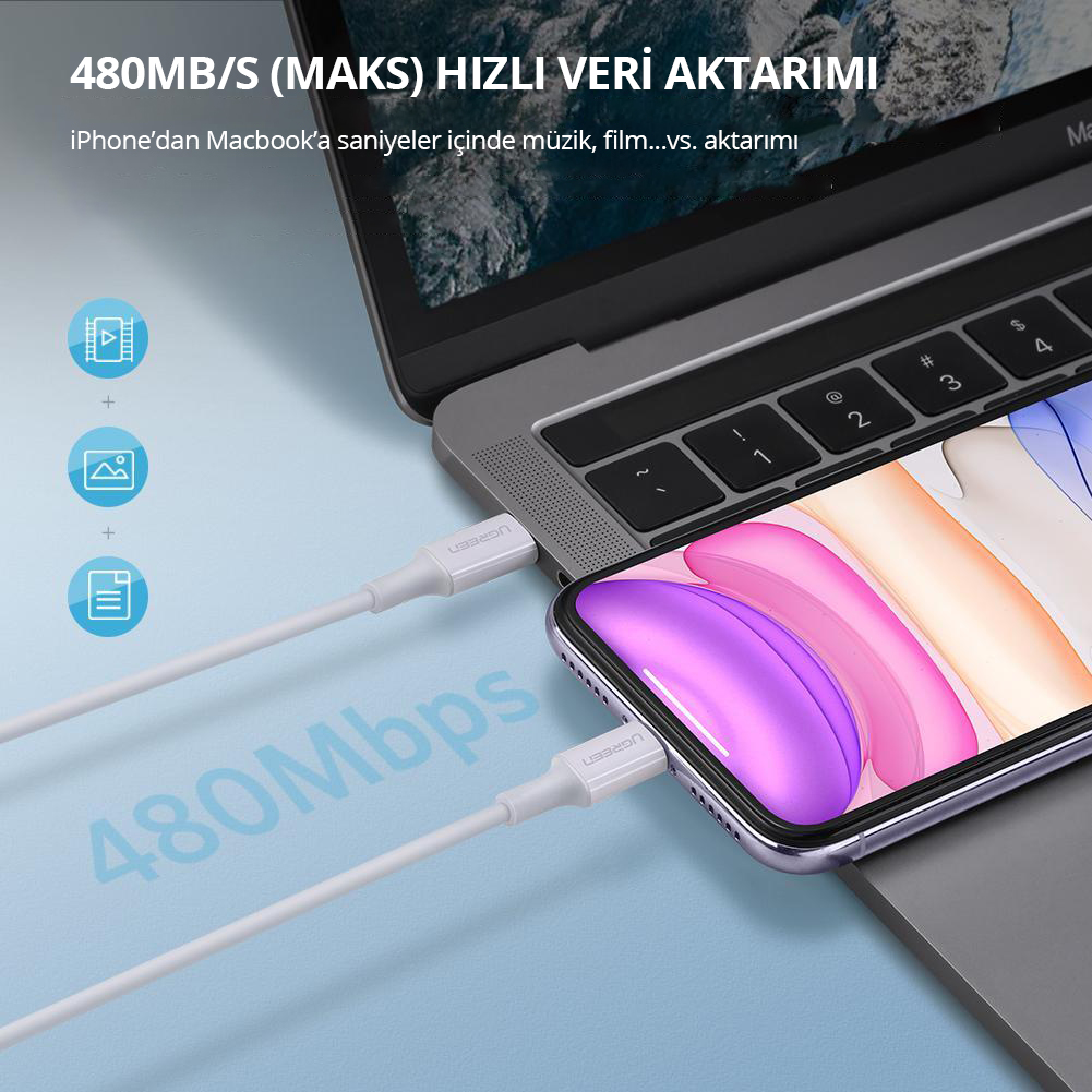 Beyaz bir şarj kablosu, 480 Mbps veri aktarımı gösteren bir telefon ve bir dizüstü bilgisayara bağlı.