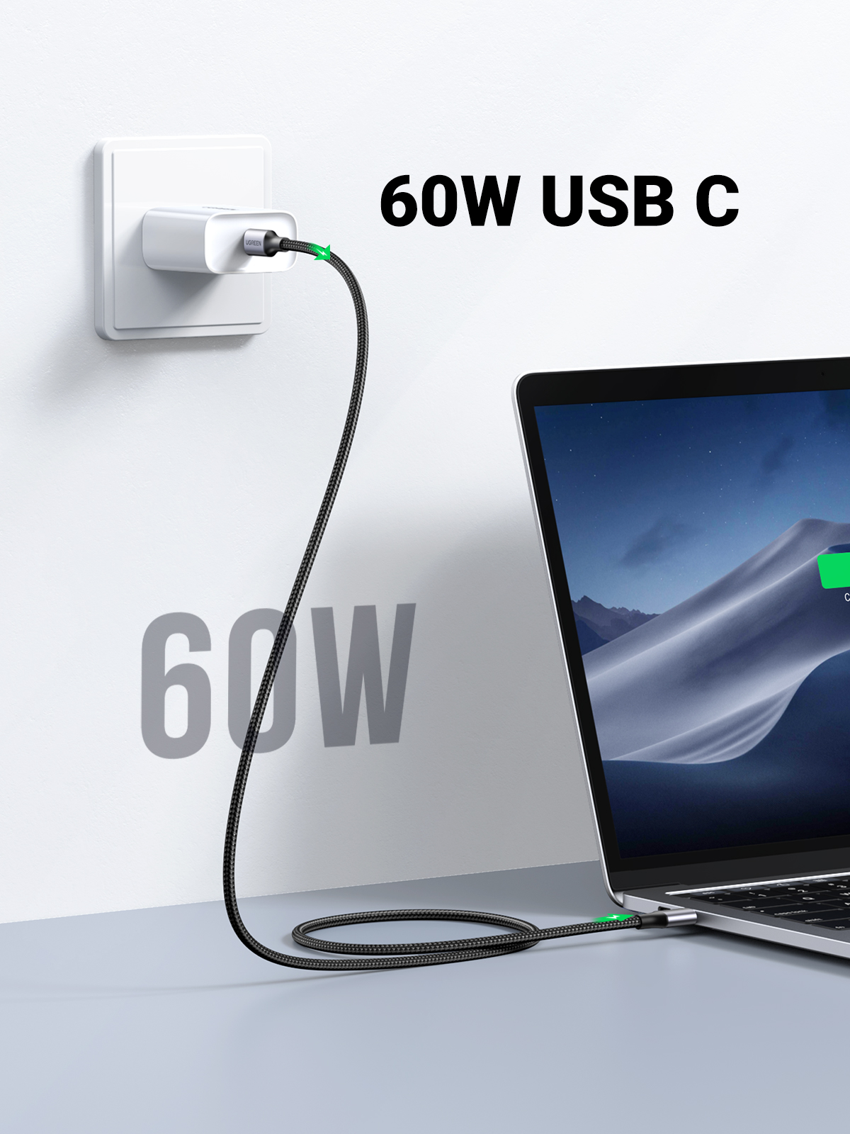 USB-C kablosuyla şarj olan dizüstü bilgisayar. Duvar prizi ve 60W metni. Beyaz duvar.