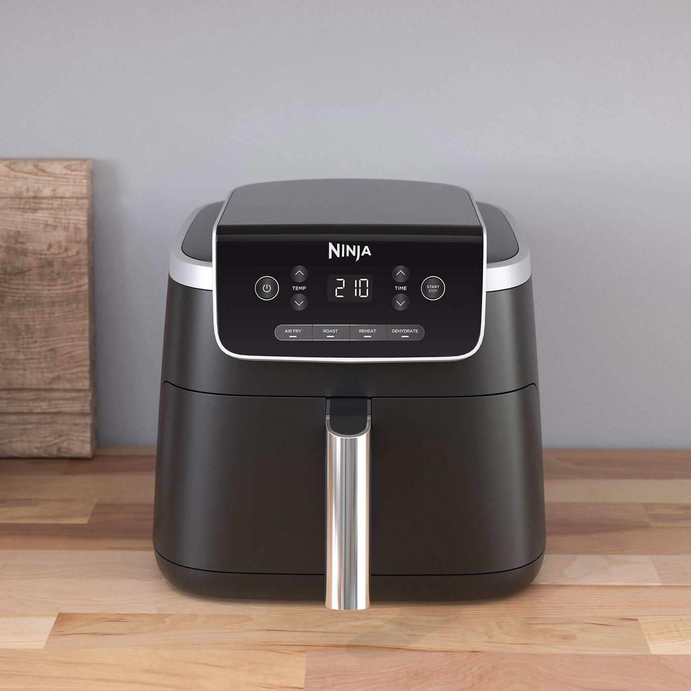 Una friggitrice ad aria nera con display digitale, su una superficie di legno. È un elettrodomestico Ninja.