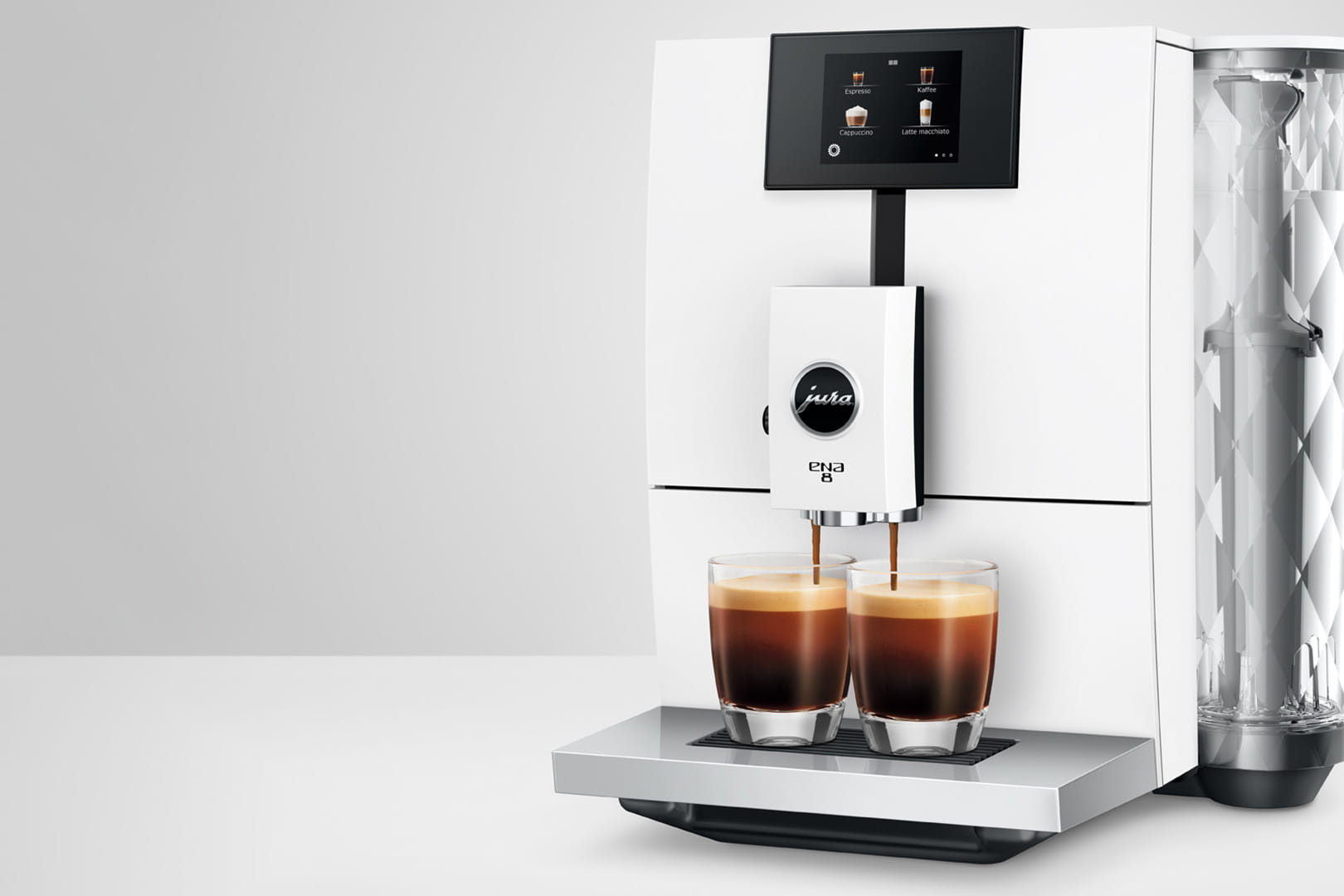 Macchina da caffè bianca che eroga espresso in due bicchieri trasparenti su un vassoio d'argento.