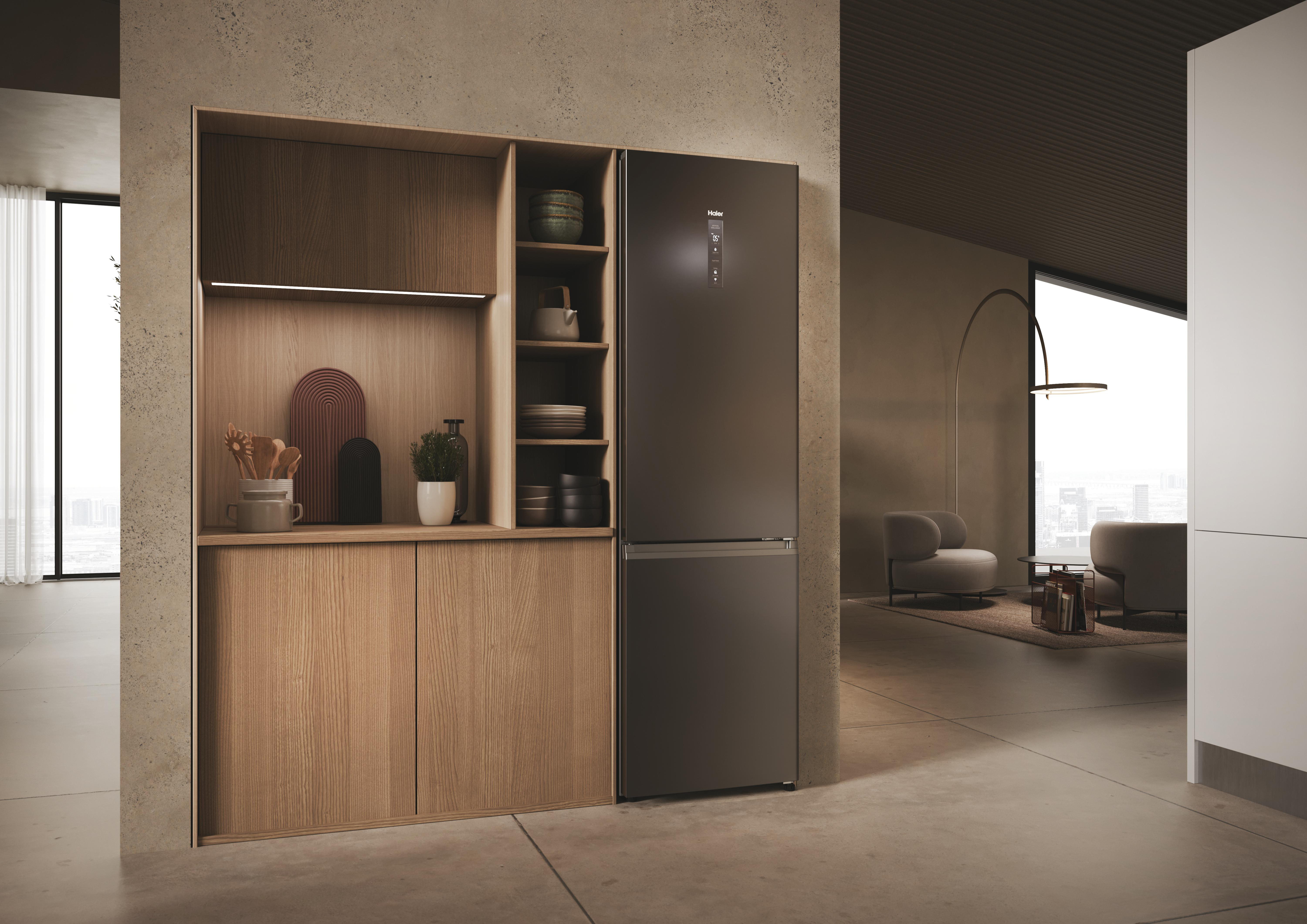 Moderne Küchenschränke. Ein dunkler Kühlschrank steht im Zentrum. Schränke sind helles Holz. Neutrales Farbschema.
