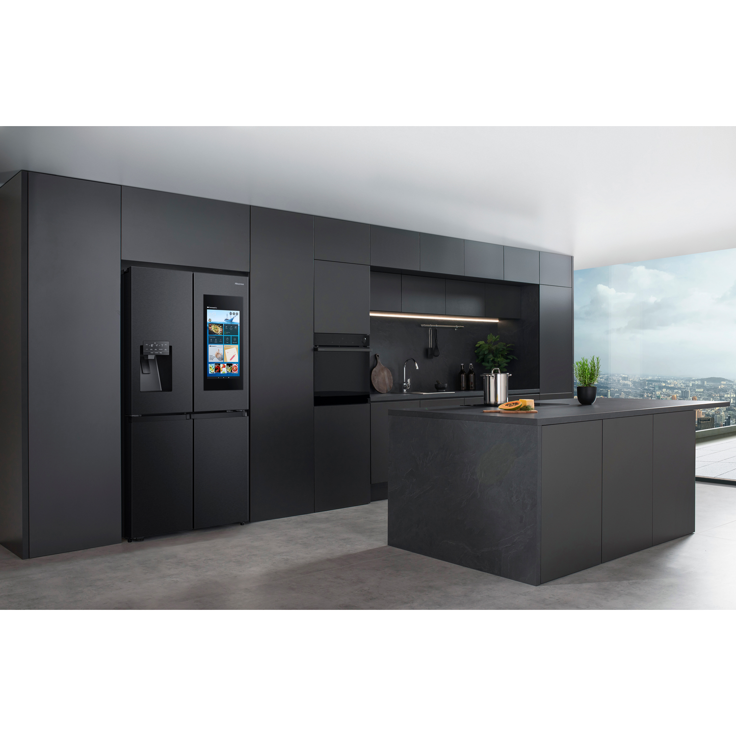 A modern black kitchen with a fridge, island, and cabinets.