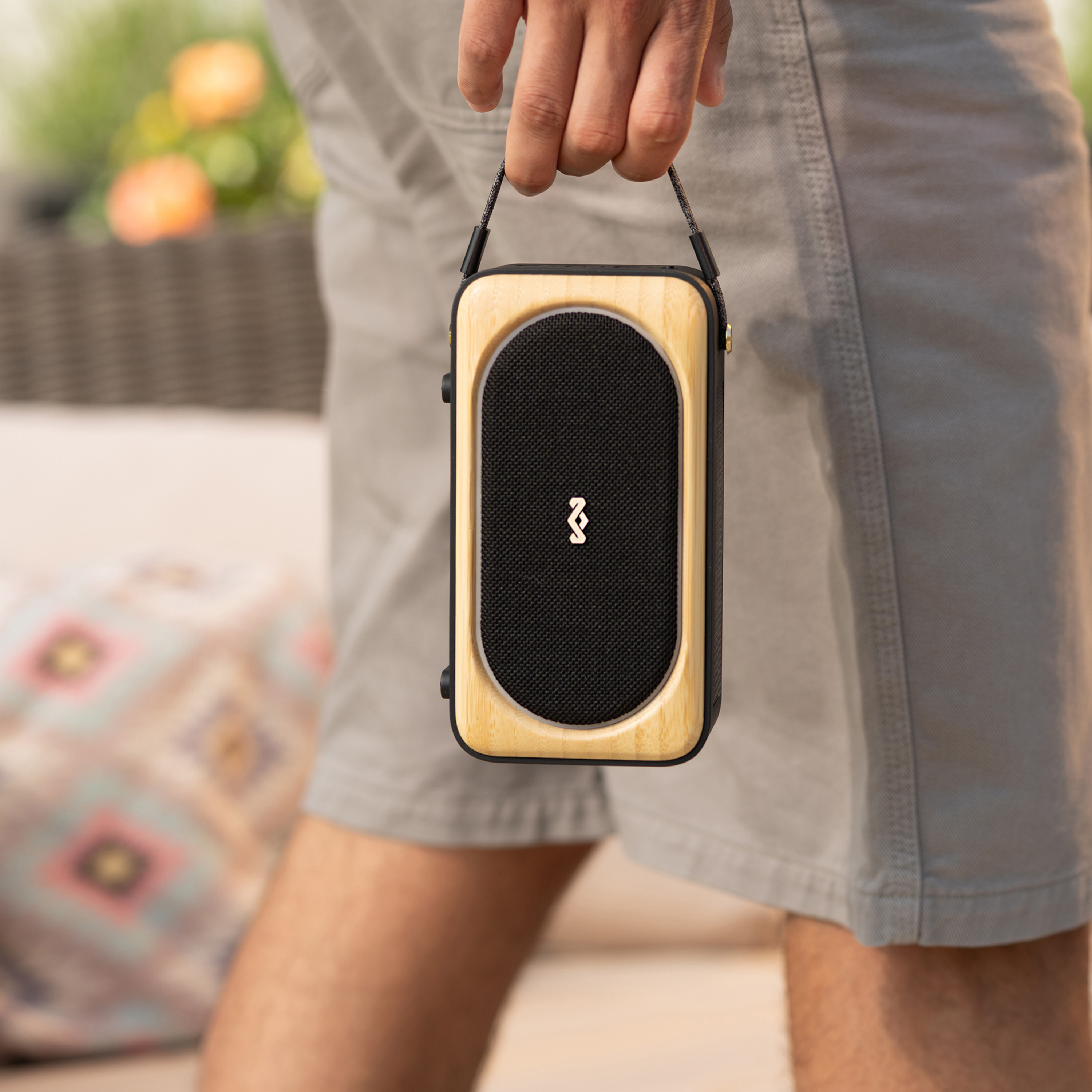 Homme tenant un haut-parleur portable avec cadre en bois.