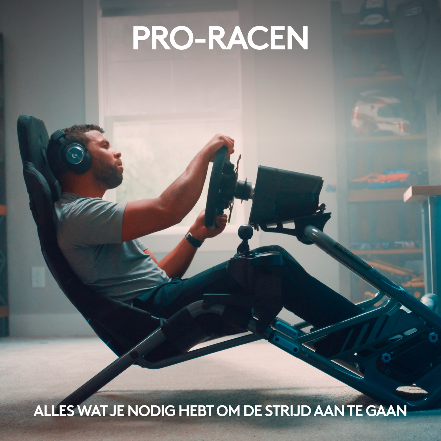 A man in a racing simulator, holding a steering wheel and wearing headphones.