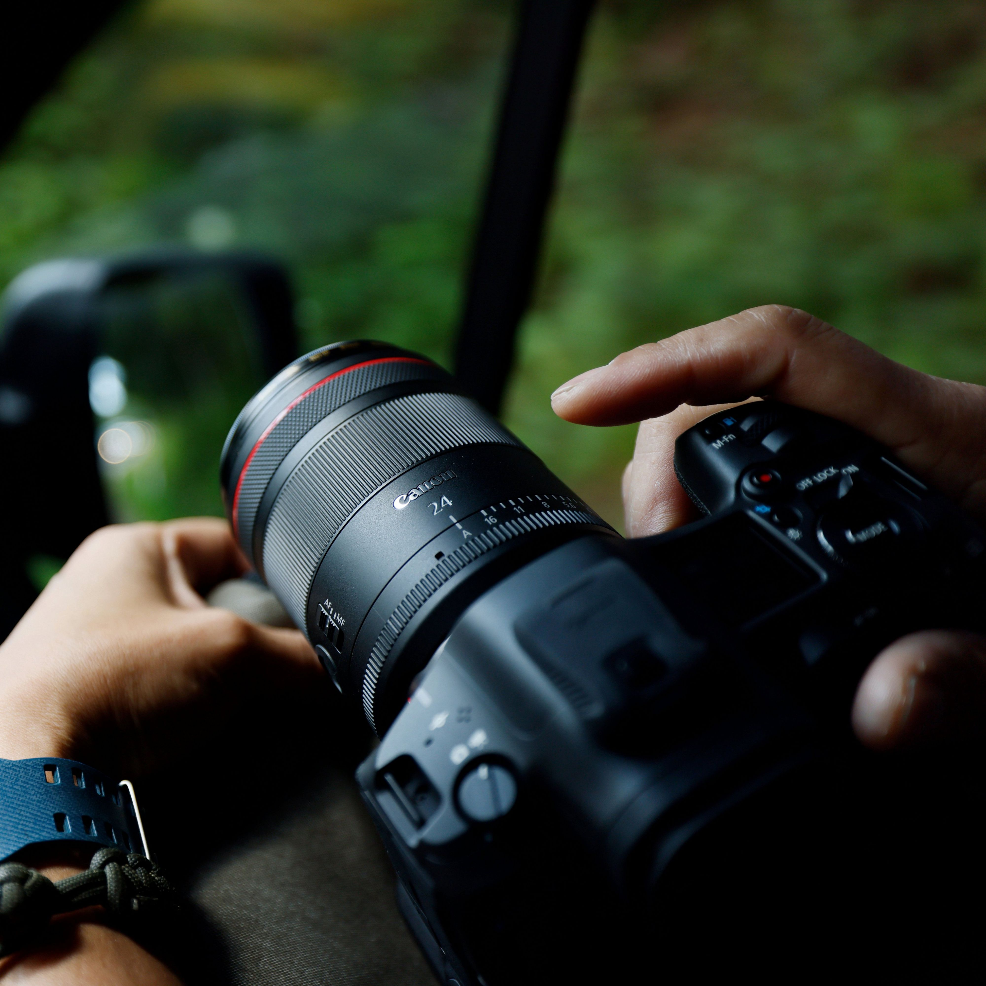 Une personne tenant un appareil photo avec un objectif, dans une voiture, prenant une photo.