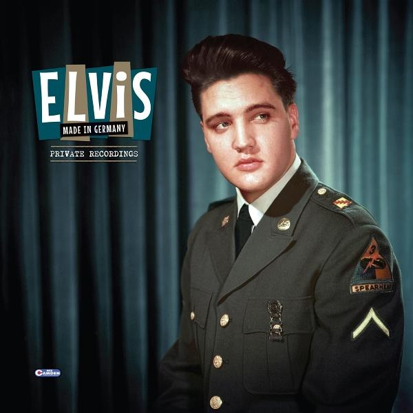 Elvis Presley in Militäruniform posiert für ein Foto. Er schaut weg, der Hintergrund ist blau.