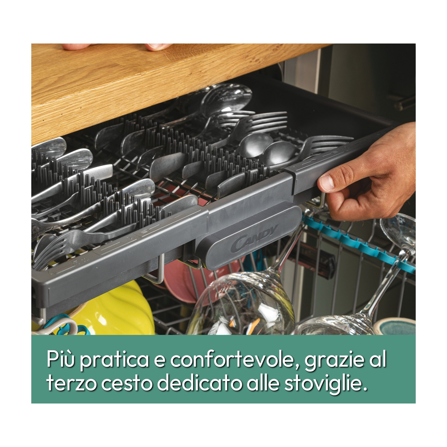 Cassetto lavastoviglie con posate. Mano che tiene un vassoio con forchette, cucchiai e coltelli.