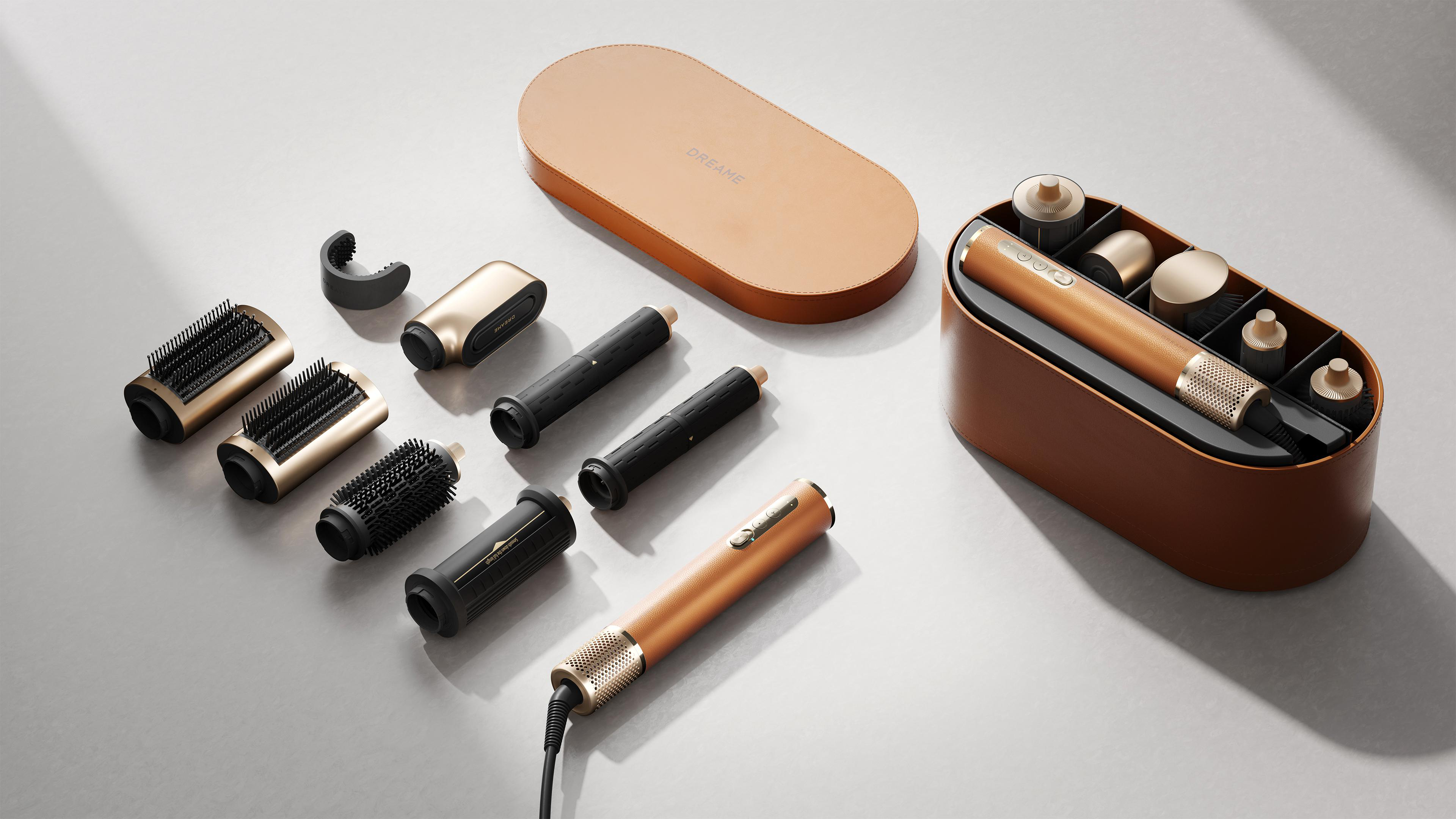 Haarstyling-Set mit gold-schwarzem Styling-Tool, Bürsten und einer Hülle auf grauer Oberfläche.