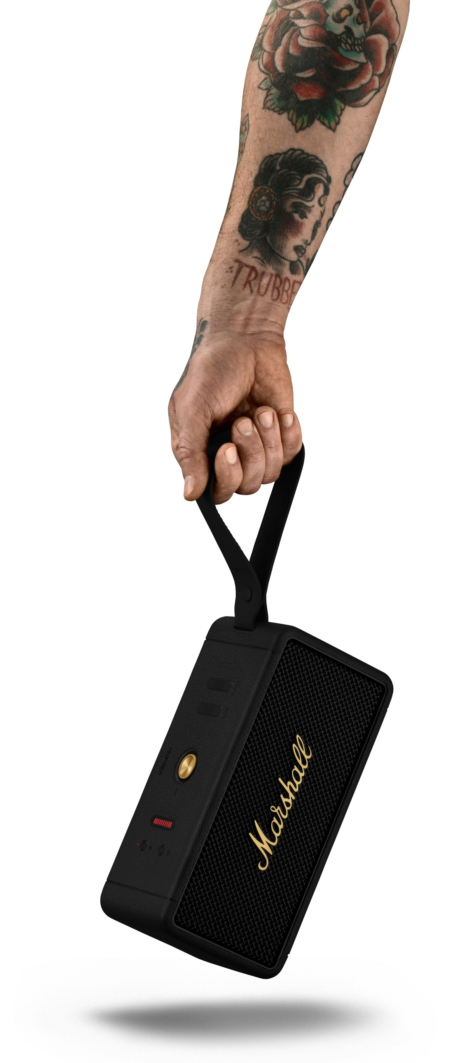 Osoba trzymająca czarny głośnik Marshall, ze skórzanym paskiem, na białym tle.